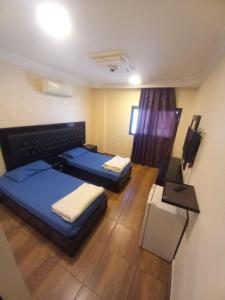 a hotel room with two beds and a television at فندق برستيج العقبه Prestige Hotel in Aqaba