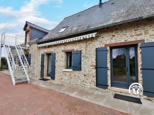 una casa de piedra con puertas azules y una escalera en La Rouaudière, en Congrier