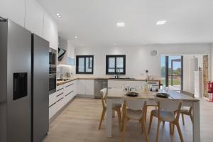 een keuken en eetkamer met een tafel en stoelen bij V3 Atlantida Farm in Quelfes