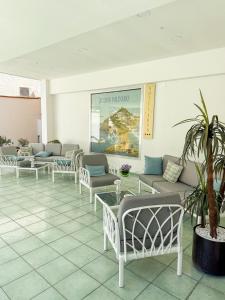 a waiting room with couches and tables and a potted plant at Hotel Residence Eden in Palinuro