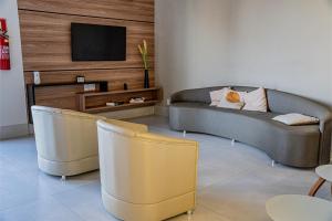 un salon avec deux canapés et une télévision dans l'établissement Norte Hotel, à Taiobeiras 28 autres photos