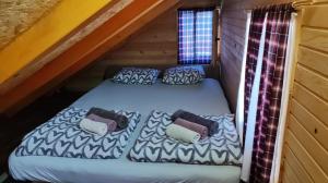 ein Bett auf dem Dachboden einer Blockhütte in der Unterkunft Splav Panda in Perućac