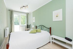 Un dormitorio con una cama blanca y una ventana. en Kastani 18 apartment, en Haapsalu