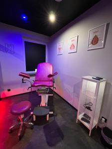 a purple room with a pink chair and a computer monitor at Czerwone Drzwi BDSM lovers Apartament dla Par in Chorzów