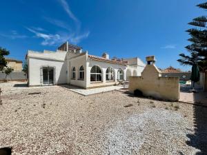 a large white house on a gravel driveway at Villa with Pool, Chill-Out & BBQ in Torrevieja