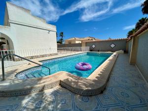 a swimming pool with a purple inflatable raft in it at Villa with Pool, Chill-Out & BBQ in Torrevieja