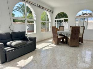 a living room with a couch and a table and chairs at Villa with Pool, Chill-Out & BBQ in Torrevieja