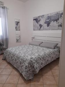 1 cama en un dormitorio con 4 cuadros en la pared en Pisa & Lucca Dream Stay, en Avane