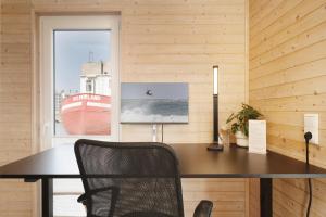 Un escritorio en una habitación con una ventana y un barco. en Hausboot Coworkingship, en Burgtiefe auf Fehmarn 