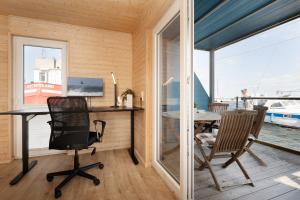 una oficina con escritorio, sillas y mesa en Hausboot Coworkingship, en Burgtiefe auf Fehmarn  31 fotos más