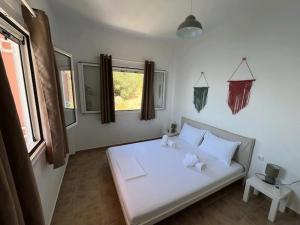 a bedroom with a white bed and a window at Casa Faustina in Ilia
