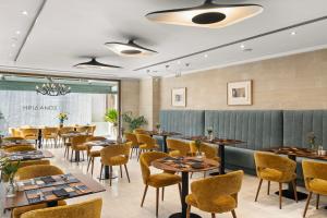 a dining room with tables and chairs at Athenaeum Eridanus Luxury Hotel in Athens