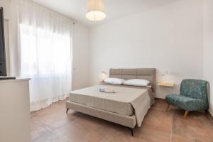 ein Schlafzimmer mit einem Bett und einem Stuhl in der Unterkunft Villa Respiro Di Puglia in Marina di Mancaversa + 35 Fotos