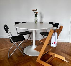 a white table with chairs and a vase with flowers at Zur Kaiserin - im Süden Berlins in Berlin