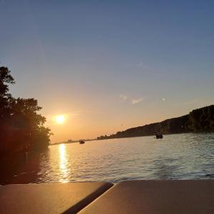 a sunset on a lake with boats in the water at Kuća za odmor Tamaris in Vukovar