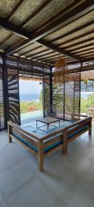 a large room with a bed and a large window at Pura Samudra - Beach House Hilltop in Bibis