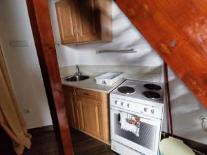 a small kitchen with a stove and a sink at Napospart 32 in Balatonlelle +3 photos