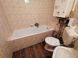 a bathroom with a white tub and a toilet at Napospart 32 in Balatonlelle