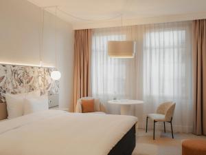 不莱梅不来梅丽笙布鲁酒店的一间带床和桌子的酒店房间