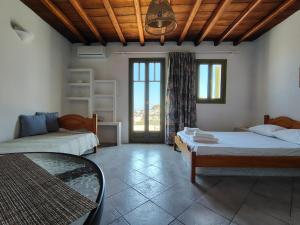 a room with two beds and a table in it at Thymariá - Chora view house in Chora Folegandros