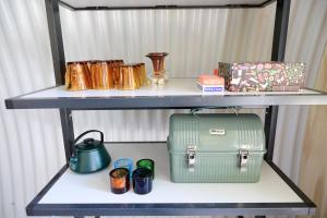 a shelf with a table with a green suitcase on it at Het Lage Noorden in Marrum