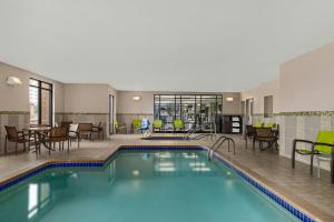 una piscina dell'hotel con sedie, tavoli e sedie di SpringHill Suites Minneapolis West St. Louis Park a Saint Louis Park