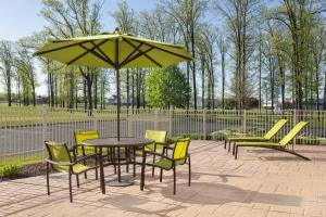 a table and chairs and an umbrella on a patio at SpringHill Suites Midland in Midland