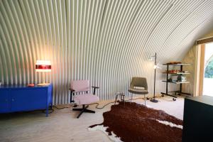 een kamer met 2 stoelen, een bureau en een lamp bij Het Lage Noorden in Marrum