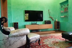 a living room with a tv and a couch and a chair at Villa Cereja in Piobesi dʼAlba