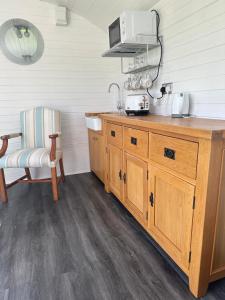 a kitchen with a wooden counter with a microwave at Secret Valley Shepherds Hut in Llanfaenor +8 photos