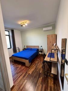 雷焦卡拉布里亚Dormire a Reggio zona Aeroporto的一间卧室设有蓝色的床,铺有木地板。