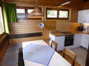 eine kleine Küche mit einem weißen Tisch und Stühlen in der Unterkunft Ferienhaus Casa del diavolo in Bernau im Schwarzwald