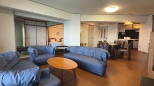 a living room with blue couches and a table at Went Members only Resort Condominium in Sumoto