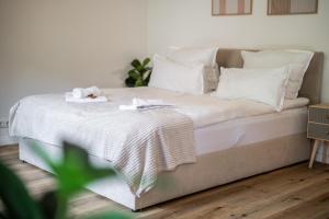 Una cama con almohadas blancas y una manta. en Hanseperle - Balkon, Smart-TV, zentral in Bremen, en Bremen