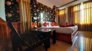 a bedroom with a bed and a desk with a desk at The Aryan hotel in Dharmsala