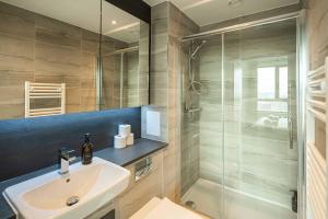 a bathroom with a sink and a shower at Bermondsey Apartments By Sleepy Lodge in London
