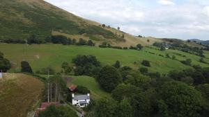 a house in the middle of a green hill at Maengwynedd, Llanrhaeadr Ym Mochnant in Oswestry