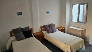 a room with two beds and a window at Habitacion en Casa compartida in Bellreguart