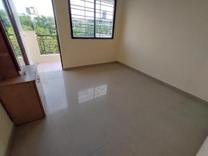 an empty room with a large window and a white floor at Professional and Sweet Home in Pune