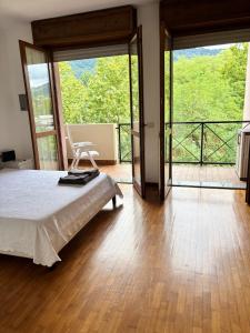 a bedroom with a bed and a balcony at Helena home in Torre De' Roveri