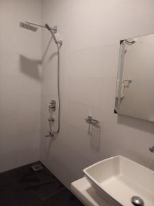 a white bathroom with a shower and a sink at The Trees Dambulla in Dambulla