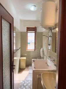 een witte badkamer met een wastafel en een bad bij Casa Francy - Taggia in Arma di Taggia