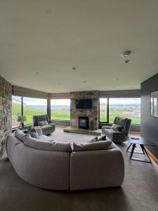 a living room with a large couch and a fireplace at Beachhaven Rossnowlagh in Rossnowlagh