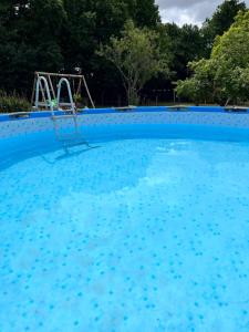 a large swimming pool with a seesaw in the background at La Grange Charton Gite in Champagne-Mouton