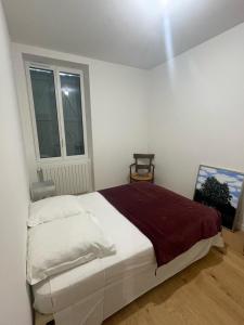 a white bedroom with a bed and a window at Belle demeure de vacances in Meyronne
