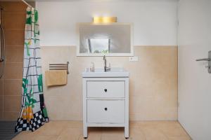Un baño con un lavabo blanco y un espejo. en Storchensommer, en Blankensee 16 fotos más
