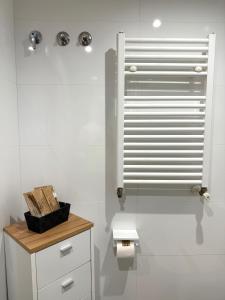 a white bathroom with a toilet and a window at Apartamento turístico Playa Valencia in Valencia +12 photos