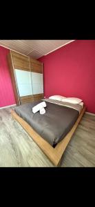 a bedroom with a large bed with a pink wall at Les Ailes de Morphée in Villé