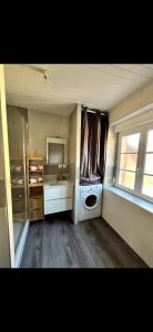 a laundry room with a washing machine and a window at Les Ailes de Morphée in Villé