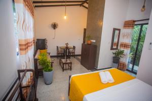 a room with a bed and a table and chairs at Vibe green villa in Unawatuna